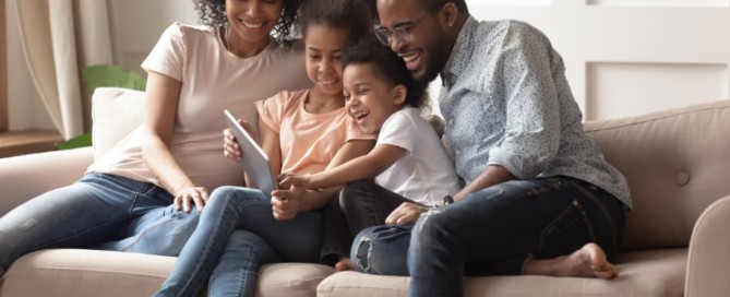 Happy family on a couch looking at tablet